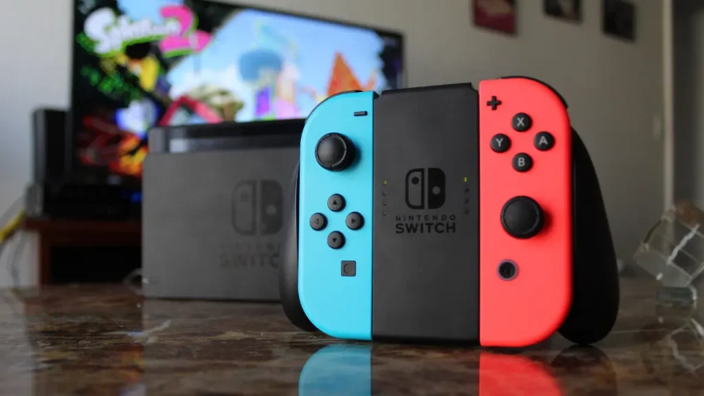 Joy-Con controllers attached to comfort grip accessory with gaming console docked in background